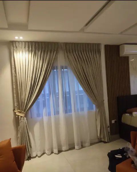 Champagne pinch-pleat curtains in a bedroom