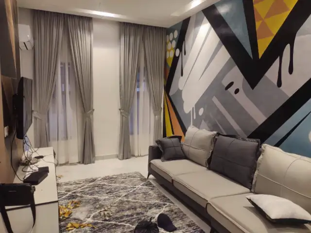 Grey curtains in a living room with a painted mural